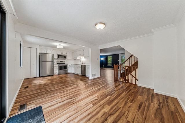 2708 Bingham Dr, Upper St Clair, PA 15241 - unfurnished living room with wood finished floors, baseboards, a sink, crown molding, and stairway