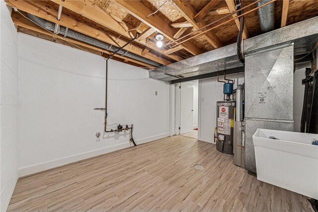 2708 Bingham Dr, Upper St Clair, PA 15241 - below grade area with water heater, wood finished floors, baseboards, and a sink
