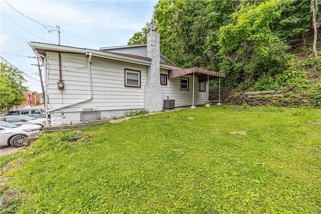 619 1st St, Verona, PA 15147 - view of property exterior featuring a yard, a chimney, and central AC