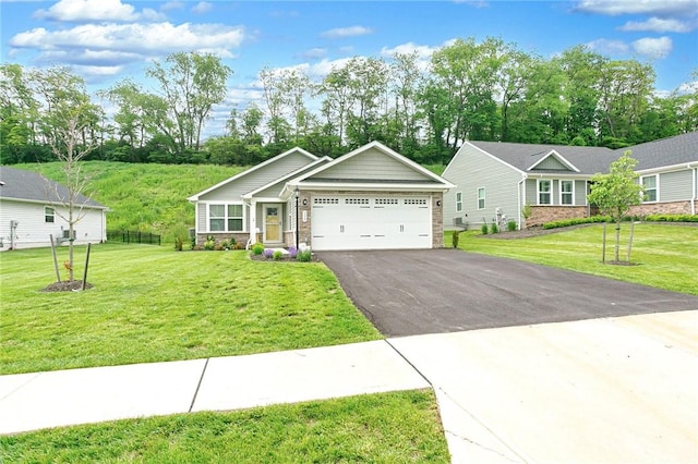 339 Nelson Dr, Monroeville, PA 15146 - ranch-style home featuring stone siding, asphalt driveway, a front yard, and an attached garage