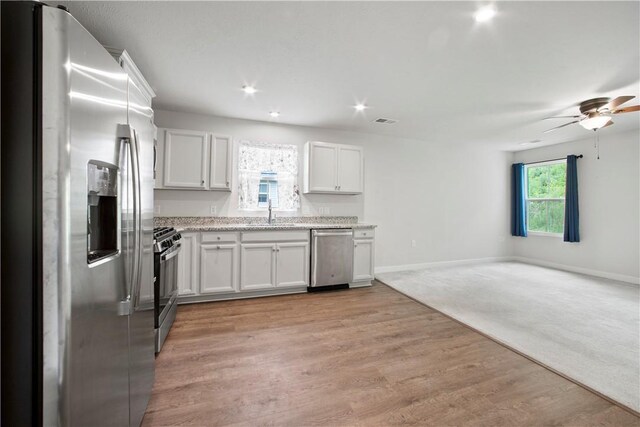 339 Nelson Dr, Monroeville, PA 15146 - kitchen with appliances with stainless steel finishes, open floor plan, a ceiling fan, white cabinets, and a sink