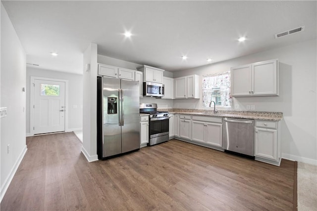 339 Nelson Dr, Monroeville, PA 15146 - kitchen with stainless steel appliances, a sink, wood finished floors, baseboards, and white cabinets