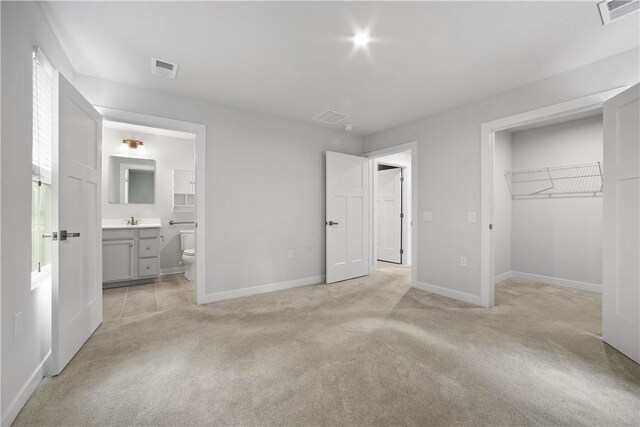 339 Nelson Dr, Monroeville, PA 15146 - unfurnished bedroom featuring light colored carpet, a spacious closet, baseboards, and a sink