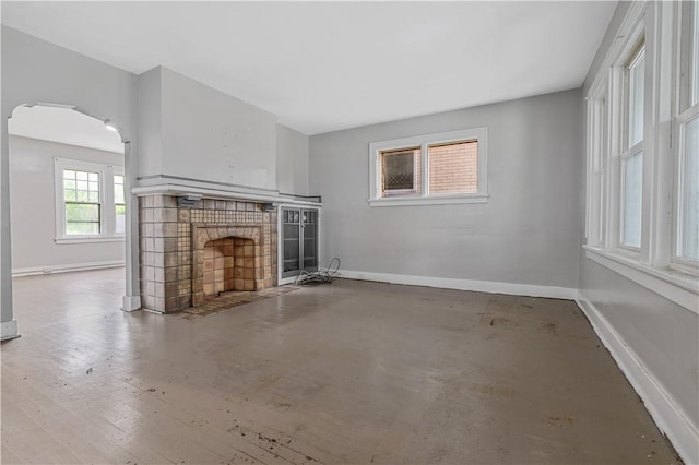 122 Margaret St, Mount Oliver, PA 15210 - unfurnished living room with arched walkways, a fireplace with flush hearth, and baseboards
