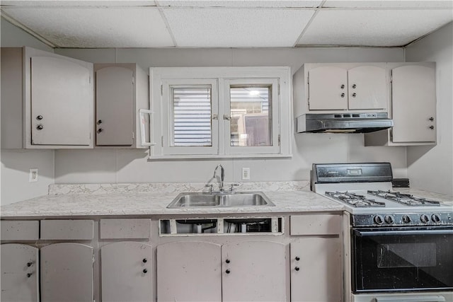 122 Margaret St, Mount Oliver, PA 15210 - kitchen featuring gas stove, under cabinet range hood, a sink, a paneled ceiling, and light countertops