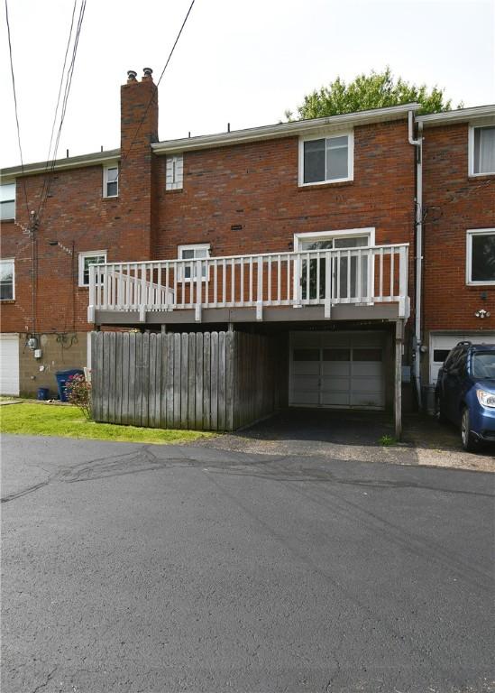 341 Macassar Dr, Baldwin Boro, PA 15236 - rear view of house with an attached garage, brick siding, a chimney, and driveway