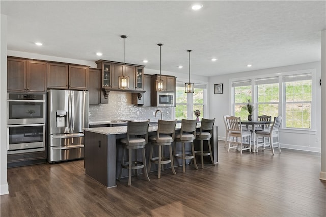 5023 Kensington Dr, Cecil, PA 15317 - kitchen featuring stainless steel appliances, baseboards, dark wood-type flooring, a kitchen island with sink, and recessed lighting