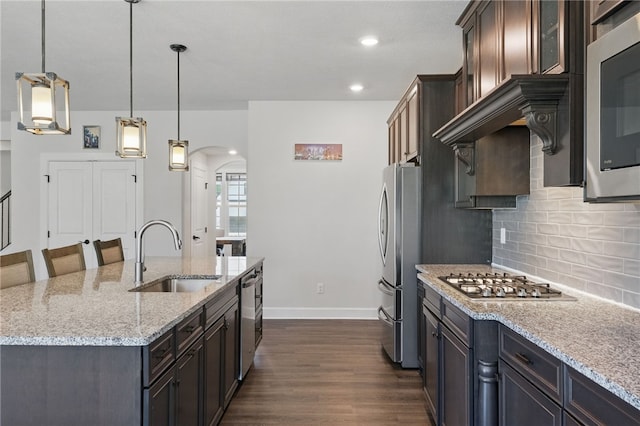 5023 Kensington Dr, Cecil, PA 15317 - kitchen featuring appliances with stainless steel finishes, a sink, dark wood-style floors, arched walkways, and backsplash