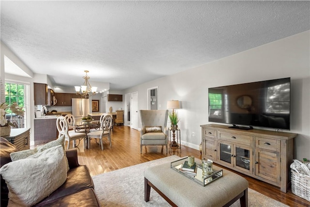 401 Pebble Creek Dr, Cranberry Twp, PA 16066 - living room with a chandelier, wood finished floors, a textured ceiling, and baseboards
