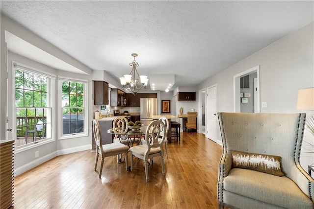401 Pebble Creek Dr, Cranberry Twp, PA 16066 - dining room featuring a chandelier, baseboards, light wood-style flooring, and a textured ceiling