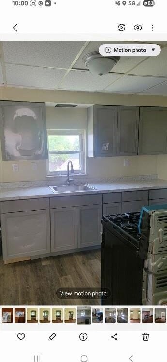 2722 Bethesda St, Carrick, PA 15227 - kitchen with black gas range, wood finished floors, light countertops, and gray cabinetry
