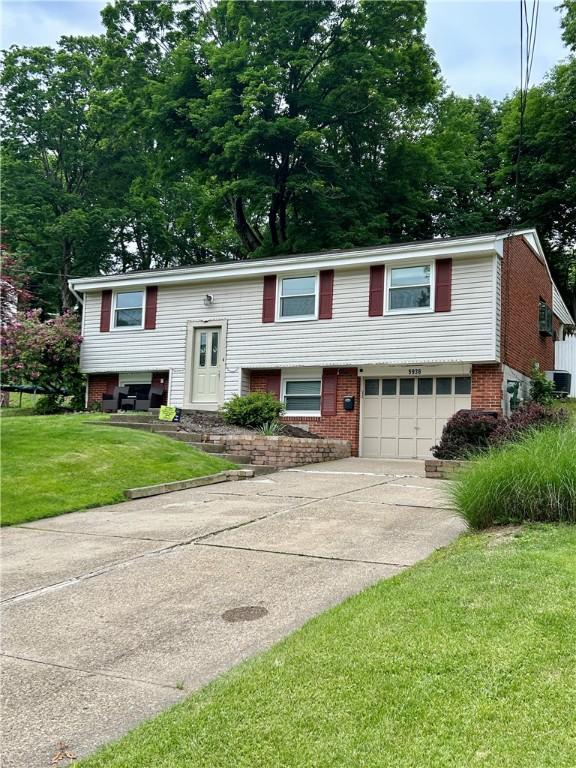 5936 Leprechaun Dr, Bethel Park, PA 15102 - raised ranch with brick siding, an attached garage, driveway, and a front yard
