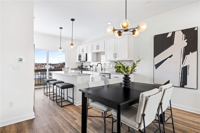 2127 Rose St, Hill District, PA 15219 - dining space featuring wood finished floors, baseboards, and a chandelier