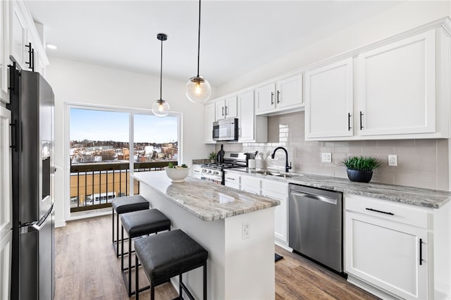 2127 Rose St, Hill District, PA 15219 - kitchen featuring appliances with stainless steel finishes, a sink, a kitchen island, backsplash, and white cabinetry