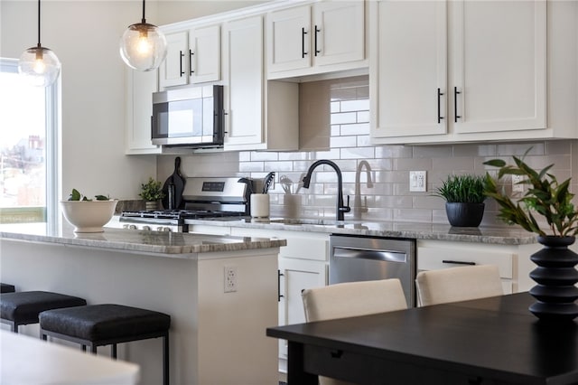 2127 Rose St, Hill District, PA 15219 - kitchen with appliances with stainless steel finishes, a breakfast bar area, tasteful backsplash, and white cabinets