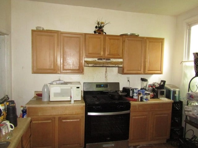 3024 Wadlow St, Brighton Heights, PA 15212 - kitchen with stainless steel gas range, white microwave, under cabinet range hood, light countertops, and brown cabinets
