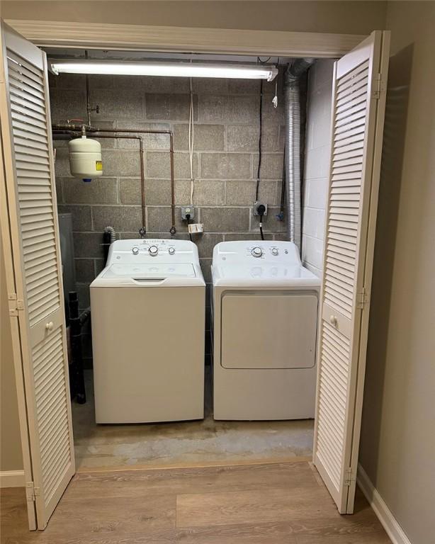 124 Hillvue Dr, Seven Fields Boro, PA 16046 - laundry room with washer and clothes dryer, concrete block wall, and light wood-style flooring