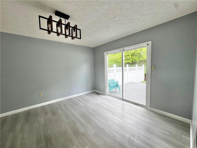 123 Pine Creek Dr, Peters Twp, PA 15367 - unfurnished dining area featuring a chandelier, wood finished floors, baseboards, and a textured ceiling