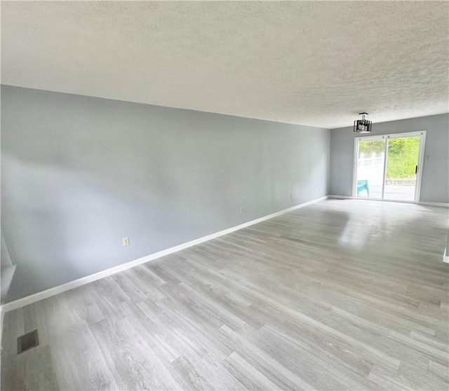 123 Pine Creek Dr, Peters Twp, PA 15367 - spare room featuring a textured ceiling, baseboards, and light wood finished floors