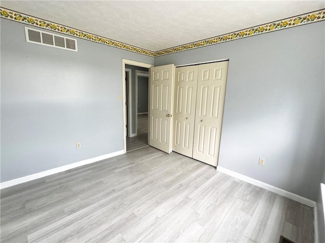 123 Pine Creek Dr, Peters Twp, PA 15367 - unfurnished bedroom with wood finished floors, baseboards, a textured ceiling, and a closet