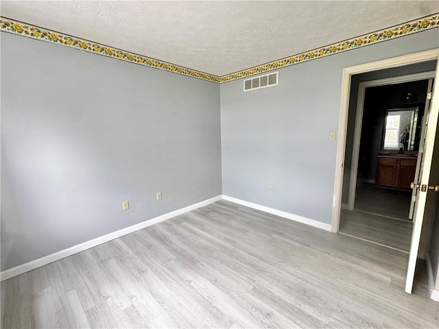 123 Pine Creek Dr, Peters Twp, PA 15367 - empty room featuring a textured ceiling, wood finished floors, and baseboards