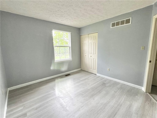 123 Pine Creek Dr, Peters Twp, PA 15367 - unfurnished bedroom with wood finished floors, a closet, a textured ceiling, and baseboards