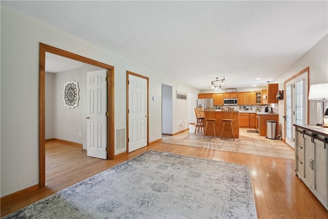 565 Leeper Rd, Green Twp, PA 15043 - kitchen featuring appliances with stainless steel finishes, light wood-style flooring, light countertops, a kitchen island, and brown cabinetry