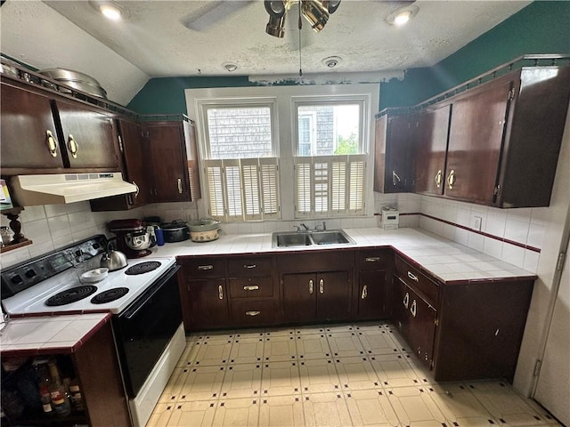 1308 Main St, Aliquippa, PA 15001 - kitchen with electric range, under cabinet range hood, tile counters, a sink, and vaulted ceiling