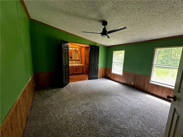 122 Arrowhead Rd, Allegheny Twp But, PA 16373 - unfurnished bedroom featuring wainscoting, a textured ceiling, ornamental molding, wood walls, and carpet flooring