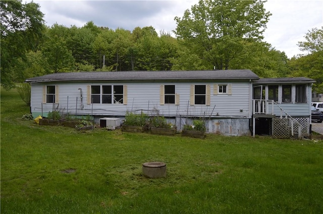 122 Arrowhead Rd, Allegheny Twp But, PA 16373 - rear view of house with a sunroom, a lawn, and a forest view