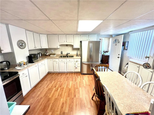 1129 1st St, Redstone Twp, PA 15442 - kitchen featuring stainless steel appliances, a sink, light wood-style flooring, white cabinets, and light countertops
