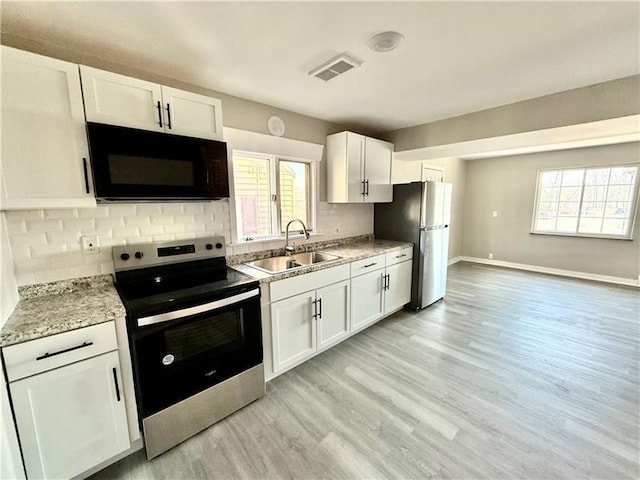 183 Pittsburgh Cir, Ellwood City Law, PA 16117 - kitchen with stainless steel appliances, a sink, backsplash, light wood-style flooring, and white cabinets