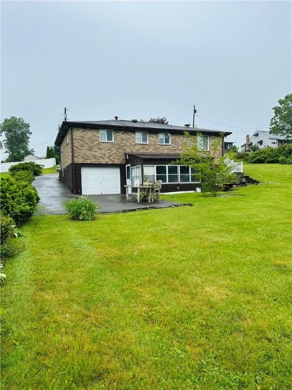 1026 Jefferson Ave, Jeannette, PA 15644 - back of property with an attached garage, a yard, driveway, and a patio area