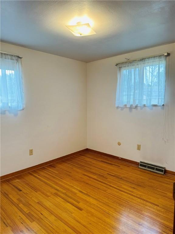 1026 Jefferson Ave, Jeannette, PA 15644 - empty room with healthy amount of natural light, light wood finished floors, and baseboards