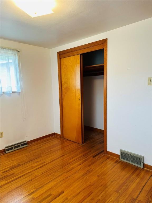 1026 Jefferson Ave, Jeannette, PA 15644 - unfurnished bedroom featuring a closet, light wood-style floors, and baseboards