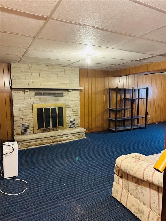 1026 Jefferson Ave, Jeannette, PA 15644 - carpeted living room with a paneled ceiling, wooden walls, and a fireplace