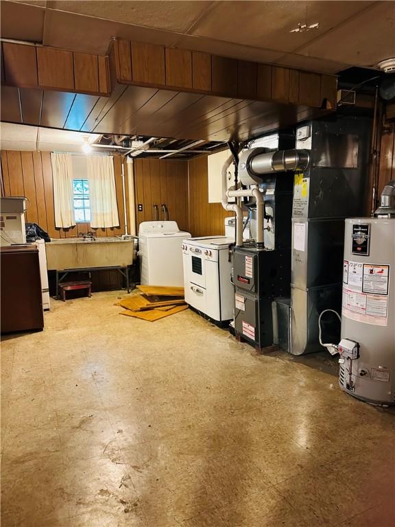 1026 Jefferson Ave, Jeannette, PA 15644 - basement with gas water heater, washer and clothes dryer, tile patterned floors, and wooden walls