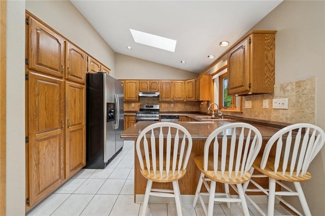 490 Hillside Ave, Monroeville, PA 15146 - kitchen with appliances with stainless steel finishes, under cabinet range hood, a peninsula, a sink, and a skylight