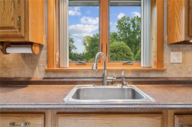 490 Hillside Ave, Monroeville, PA 15146 - kitchen featuring a sink, dark countertops, decorative backsplash, and brown cabinetry