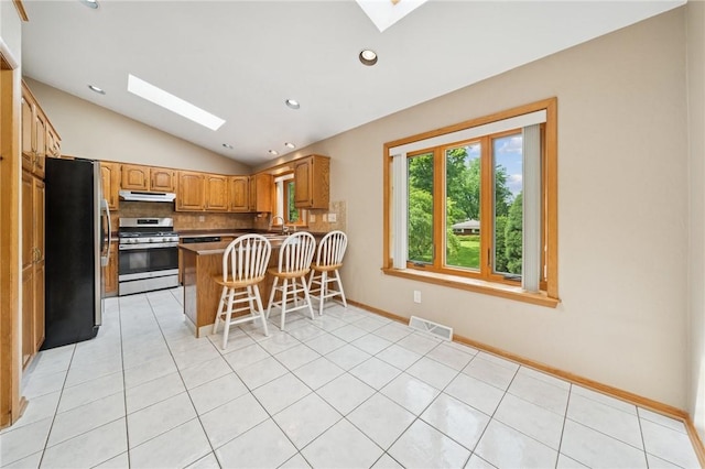 490 Hillside Ave, Monroeville, PA 15146 - kitchen featuring a skylight, appliances with stainless steel finishes, lofted ceiling, a peninsula, and backsplash