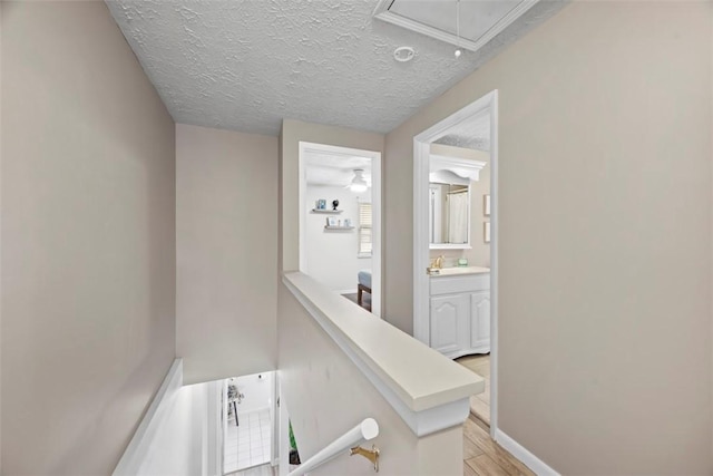 113 Stoney Creek Ct, Seven Fields Boro, PA 16046 - hallway with attic access, a textured ceiling, light wood finished floors, an upstairs landing, and baseboards