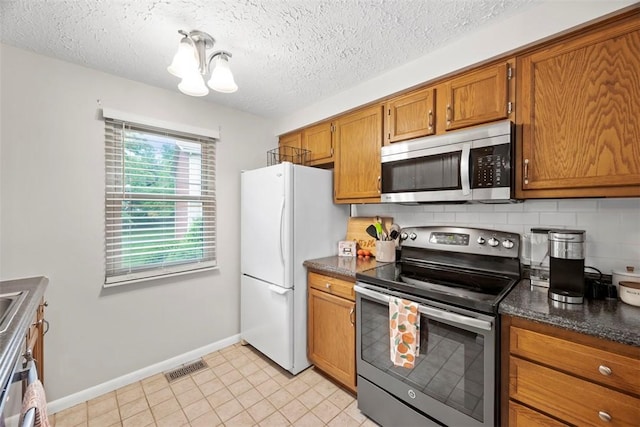 113 Stoney Creek Ct, Seven Fields Boro, PA 16046 - kitchen with appliances with stainless steel finishes, brown cabinets, baseboards, backsplash, and a textured ceiling