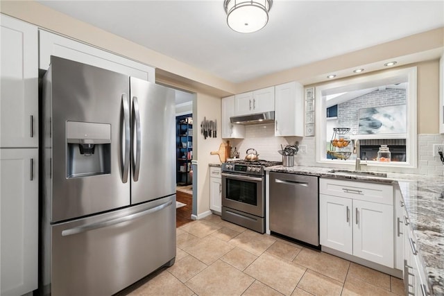724 Pine Valley Dr, Plum Boro, PA 15239 - kitchen with stainless steel appliances, under cabinet range hood, white cabinetry, light tile patterned floors, and backsplash