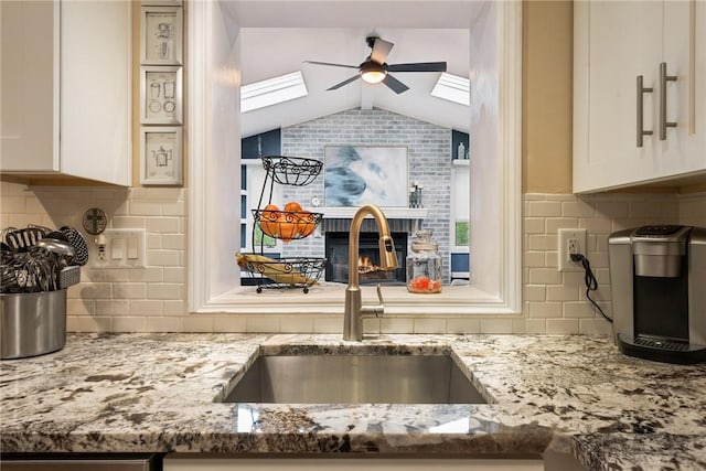 724 Pine Valley Dr, Plum Boro, PA 15239 - kitchen with a sink, ceiling fan, backsplash, light stone counters, and lofted ceiling