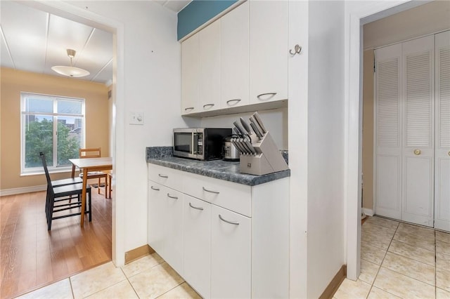5 Bayard Rd Unit 808, Shadyside, PA 15213 - kitchen featuring stainless steel microwave, baseboards, dark countertops, and white cabinets