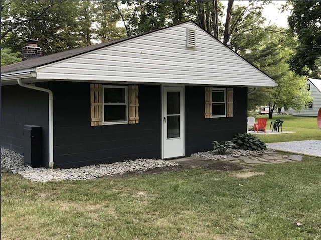 2057 Mccann Dr, Shenango, PA 16424 - view of front of property with concrete block siding, a front yard, and a chimney
