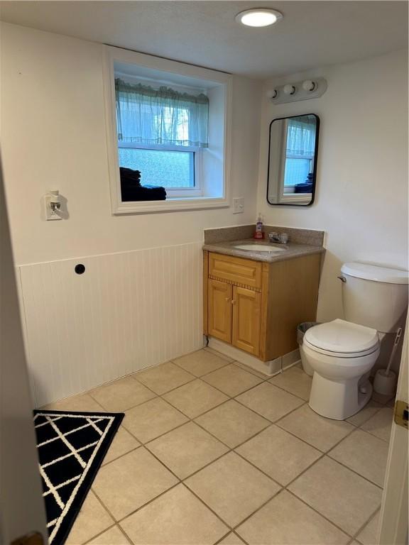 2057 Mccann Dr, Shenango, PA 16424 - bathroom with vanity, toilet, tile patterned flooring, and wainscoting