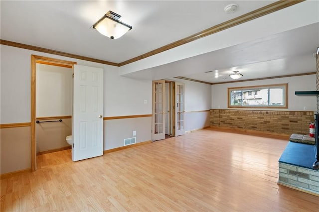 116 Buttercup Dr, Cranberry Twp, PA 16066 - unfurnished living room featuring wood finished floors, ornamental molding, french doors, brick wall, and baseboards