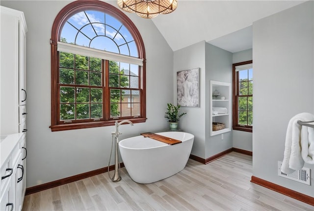 5010 W Grove Ln, Pine Twp Nal, PA 15044 - bathroom with a soaking tub, wood finished floors, vanity, baseboards, and lofted ceiling