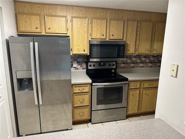 9015 James Ct Unit 9015, Hopewell Twp Bea, PA 15001 - kitchen featuring appliances with stainless steel finishes, brown cabinets, decorative backsplash, and light tile patterned floors
